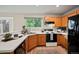 Spacious kitchen featuring wood cabinets, white countertops, and black appliances at 19229 E Legend Ave, Parker, CO 80134