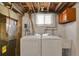 Basement laundry area equipped with a washer, dryer, and utility sink for convenience at 1418 Perry St, Denver, CO 80204