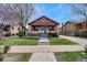 Charming bungalow with a brick facade, showcasing a neat front yard and inviting entryway at 1418 Perry St, Denver, CO 80204