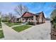 Charming brick home with a well-maintained front yard and driveway leading to a detached garage at 1418 Perry St, Denver, CO 80204