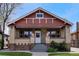 Inviting brick bungalow featuring a well-manicured lawn and a classic front porch for relaxation at 1418 Perry St, Denver, CO 80204