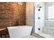Stylish bathroom featuring wood accent wall, soaking tub, and glass-enclosed shower at 415 Butte Pkwy, Golden, CO 80403