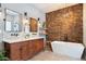 Modern bathroom with double vanity, wood accent wall, and freestanding tub at 415 Butte Pkwy, Golden, CO 80403