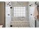 Luxurious shower with dual shower heads, marble tiling, and a built-in bench at 415 Butte Pkwy, Golden, CO 80403