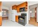 Efficient kitchen featuring classic appliances, wood cabinets, and tile flooring at 3515 Grape St, Denver, CO 80207