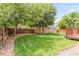 Picture of a large backyard area with manicured lawn, mature trees, stone landscaping and wooden fence and deck at 10591 Hyacinth St, Highlands Ranch, CO 80129