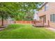 Spacious backyard featuring a lush lawn, wood fence, mature trees, and a cozy deck for outdoor enjoyment at 10591 Hyacinth St, Highlands Ranch, CO 80129