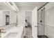 Bright bathroom with double vanity, view into bedroom and walk-in shower with glass door at 10591 Hyacinth St, Highlands Ranch, CO 80129