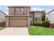 Two-story home showcasing a two car garage, brick accents, well maintained lawn and inviting curb appeal at 10591 Hyacinth St, Highlands Ranch, CO 80129