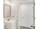 Bright powder room featuring a white vanity, brushed nickel faucet, and framed mirror at 10591 Hyacinth St, Highlands Ranch, CO 80129