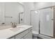 Bright bathroom featuring a modern vanity with quartz countertop and a glass-enclosed shower at 8672 Pennycress Dr, Littleton, CO 80125