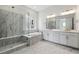 Luxurious bathroom with marble accents, a glass-enclosed shower, and dual vanity sinks for modern comfort at 8672 Pennycress Dr, Littleton, CO 80125