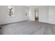 Spacious bedroom with two windows and modern carpeting, adjacent to a well-lit bathroom for convenience at 8672 Pennycress Dr, Littleton, CO 80125