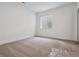 Minimalist bedroom with neutral carpet, natural light, and egress window at 8672 Pennycress Dr, Littleton, CO 80125