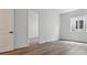 Another bedroom featuring hardwood floors, white walls, and a doorway leading to another room at 8672 Pennycress Dr, Littleton, CO 80125