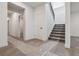 Bright entryway with stairs leading to upper level, neutral carpet and white walls at 8672 Pennycress Dr, Littleton, CO 80125