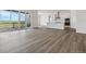 Open-concept living area with wood-look flooring, sliding glass doors and adjacent to the modern kitchen at 8672 Pennycress Dr, Littleton, CO 80125