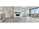 Spacious living room with a modern fireplace, lots of natural light and wood-look flooring at 8672 Pennycress Dr, Littleton, CO 80125