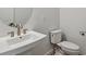 Sleek powder room featuring a white vanity, a modern faucet, round mirror and a comfort height toilet at 8672 Pennycress Dr, Littleton, CO 80125