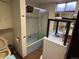 Basement bathroom shows blue tiled bath and updated shower with washer/dryer at 3910 E Orchard Rd, Centennial, CO 80121