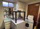 Basement laundry room featuring dated washer/dryer units and basic cabinets at 3910 E Orchard Rd, Centennial, CO 80121
