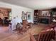 Cozy living room featuring a brick fireplace, built-in bookshelves, and hardwood floors at 3910 E Orchard Rd, Centennial, CO 80121