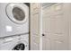 Convenient laundry area equipped with a stacked washer and dryer unit next to a door at 2215 Meade St, Denver, CO 80211