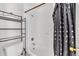 A cozy bathroom featuring a shower-tub with a stylish curtain and storage shelves at 8826 E Florida Ave # 117, Denver, CO 80247