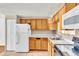 Functional kitchen featuring wood cabinets, tiled floor, and essential appliances at 8826 E Florida Ave # 117, Denver, CO 80247