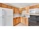 Functional kitchen with wood cabinets, updated appliances, and a tiled floor at 8826 E Florida Ave # 117, Denver, CO 80247