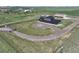 Expansive aerial view of home with circular driveway, dark metal roof, fenced perimeter, and green surrounding landscape at 3308 County Road 19, Fort Lupton, CO 80621