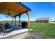 Covered patio featuring ceiling fans, seating area, barbecue, and expansive views of the property and metal shop at 3308 County Road 19, Fort Lupton, CO 80621