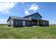 Modern farmhouse featuring a metal roof, timber frame, and large windows, set on a spacious green lot at 3308 County Road 19, Fort Lupton, CO 80621