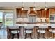 Large kitchen island with seating and pendant lighting, along with modern appliances and dark wood cabinets at 3308 County Road 19, Fort Lupton, CO 80621