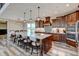 Spacious kitchen with a large island, dark wood cabinetry, modern pendant lighting, and stainless steel appliances at 3308 County Road 19, Fort Lupton, CO 80621
