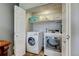 Convenient laundry room with a washer and dryer and shelving for storage, all behind folding doors at 3308 County Road 19, Fort Lupton, CO 80621