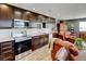 Cozy living room next to a kitchen with stainless steel appliances, dark cabinets and light countertops at 3308 County Road 19, Fort Lupton, CO 80621