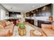 Open concept living room and kitchen featuring stainless steel appliances, dark cabinets and comfortable leather seating at 3308 County Road 19, Fort Lupton, CO 80621