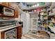 Well-organized walk-in pantry with shelves, wine cooler, microwave, toaster oven and countertop space at 3308 County Road 19, Fort Lupton, CO 80621