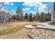 Spacious backyard offers a patio and gravel area with mature trees providing shade and privacy for outdoor enjoyment at 7271 Brixham Cir, Castle Pines, CO 80108