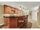 A basement bar featuring wooden cabinets, stools, and granite countertops at 7271 Brixham Cir, Castle Pines, CO 80108
