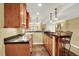 A basement bar featuring wooden cabinets, stools, and granite countertops at 7271 Brixham Cir, Castle Pines, CO 80108