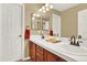 Bathroom featuring 2 mirrors, sinks, and a door at 7271 Brixham Cir, Castle Pines, CO 80108
