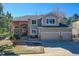 Charming two-story home showcasing brick and siding details, plus a three car garage and landscaped front yard at 7271 Brixham Cir, Castle Pines, CO 80108