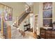 Bright foyer features a staircase with wood banister and iron spindles, complemented by tile flooring and warm tones at 7271 Brixham Cir, Castle Pines, CO 80108