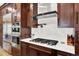 Gourmet kitchen featuring high-end stainless steel appliances, a gas cooktop, and stylish dark wood cabinets at 7271 Brixham Cir, Castle Pines, CO 80108