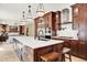 Open kitchen featuring a large island with seating, modern appliances, and seamless flow to the living area at 7271 Brixham Cir, Castle Pines, CO 80108