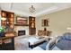 Cozy living room with stone fireplace, built-in shelves, unique wood accents, and large windows at 7271 Brixham Cir, Castle Pines, CO 80108