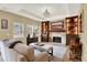 Inviting living room with stone fireplace, built-in shelving, tray ceiling, and lots of natural light at 7271 Brixham Cir, Castle Pines, CO 80108
