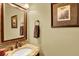 Well-lit powder room with marble countertop, decorative mirror and lighting, and neutral colors at 7271 Brixham Cir, Castle Pines, CO 80108